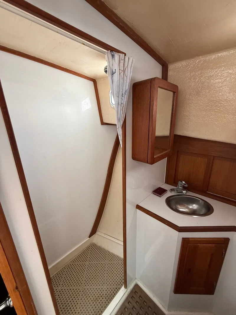 Slide: The Image of 1998 Wilbur 38 Downeast boat bathroom with sink, mirror, and shower area. - 23