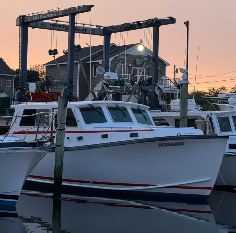 Slide: The Image of 1998 Wilbur 38 Downeast boat docked at marina during sunset. - 8