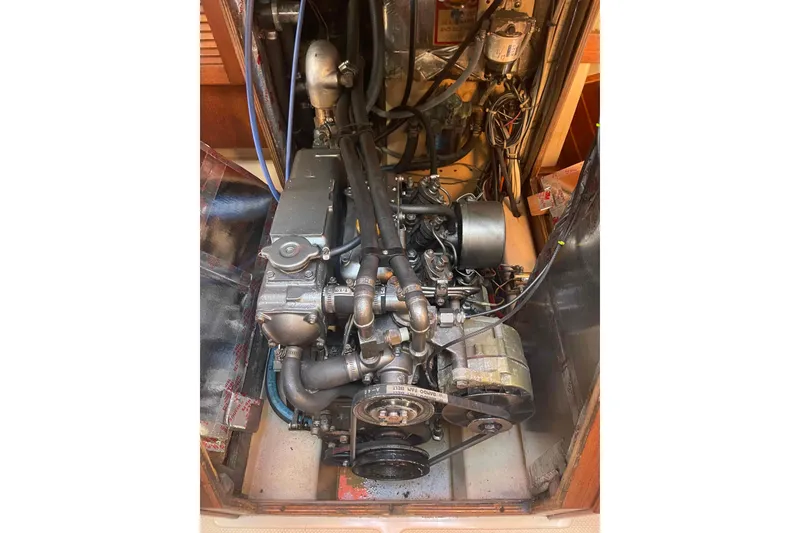 Slide: The Image of Engine compartment of a 1989 Island Packet 35 sailboat, showcasing mechanical components. - 11