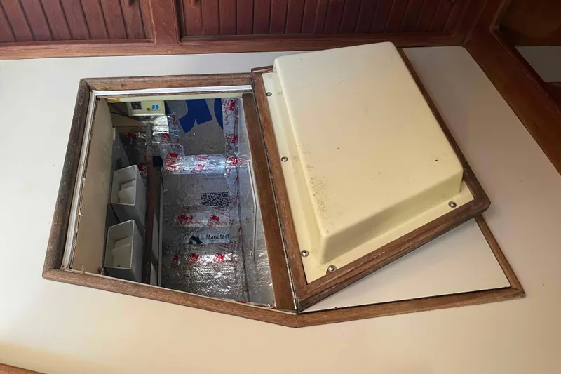 Slide: The Image of Hatch opening on 1989 Island Packet 35 sailboat, revealing insulated compartment. - 22