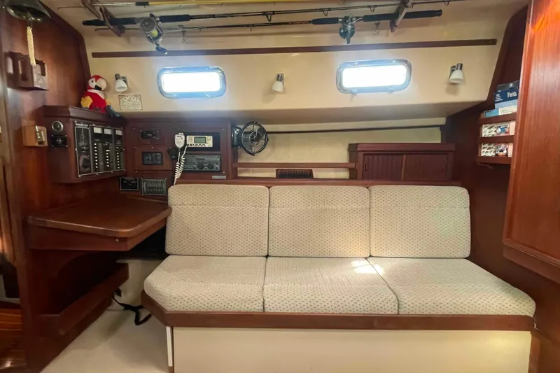 Slide: The Image of Interior of 1989 Island Packet 35 sailboat with navigation station and cushioned seating. - 24