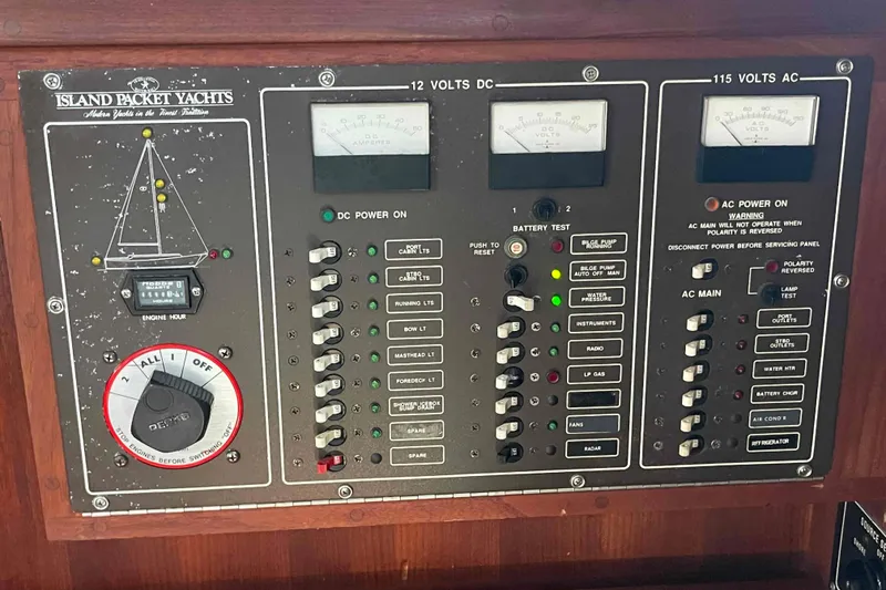 Slide: The Image of Control panel of a 1989 Island Packet 35 yacht, featuring various switches and gauges. - 26