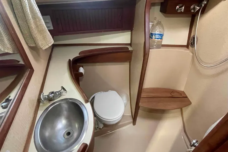 Slide: The Image of 1989 Island Packet 35 yacht bathroom with sink, toilet, and shower area. - 36