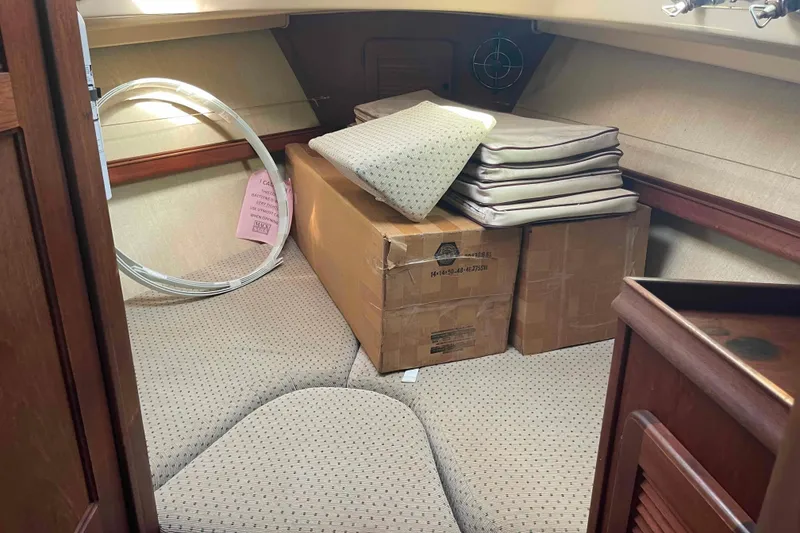 Slide: The Image of Interior cabin of 1989 Island Packet 35 sailboat with cushions and boxes. - 37