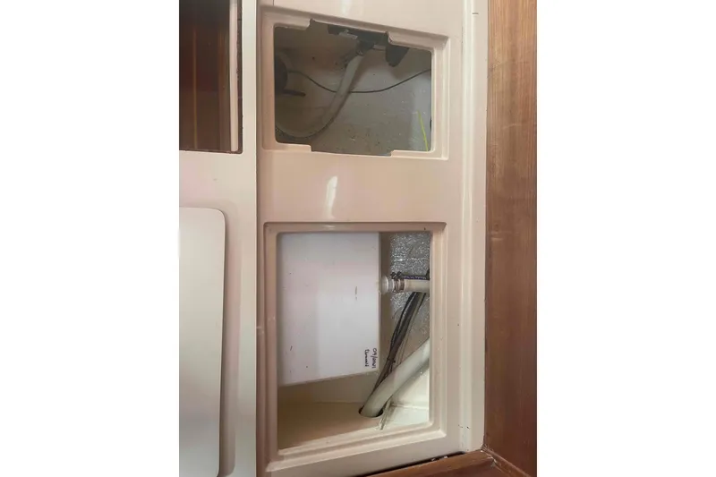 Slide: The Image of Interior compartment of 1989 Island Packet 35 sailboat, showing wiring and plumbing. - 40