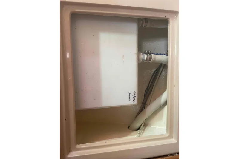 Slide: The Image of Interior compartment of 1989 Island Packet 35 sailboat with visible plumbing and wiring. - 41