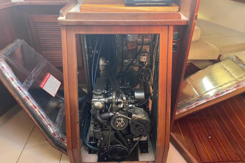 Slide: The Image of 1989 Island Packet 35 sailboat engine compartment with open wooden panels. - 47