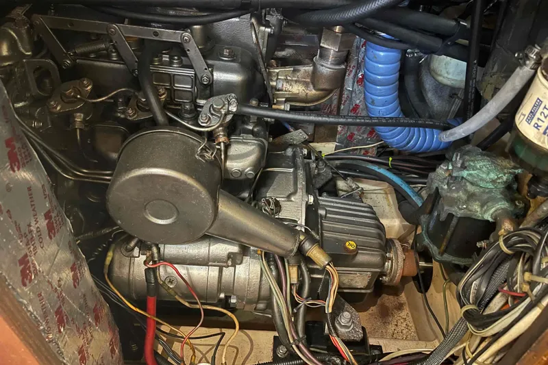 Slide: The Image of Engine compartment of a 1989 Island Packet 35 sailboat, showcasing mechanical components and wiring. - 50