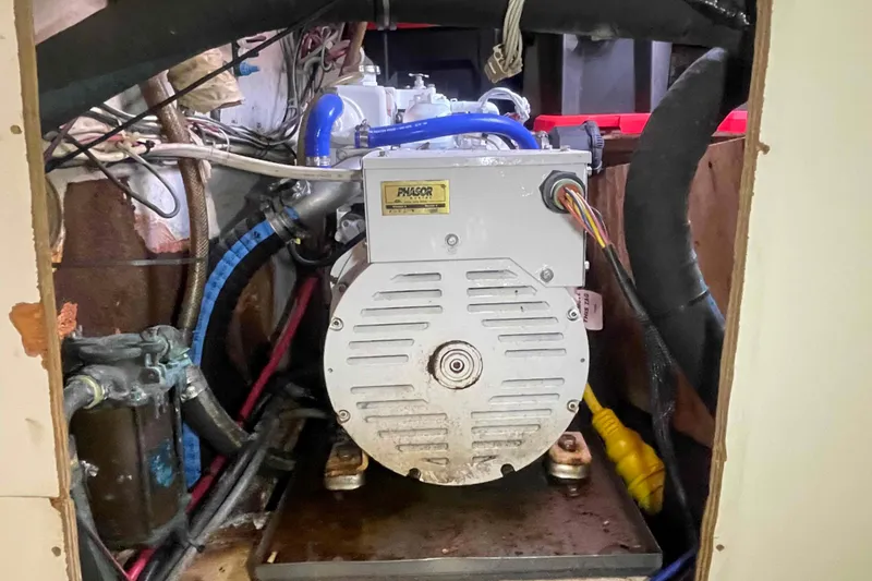 Slide: The Image of Engine compartment of a 1989 Island Packet 35 sailboat, featuring a Phasor generator. - 54