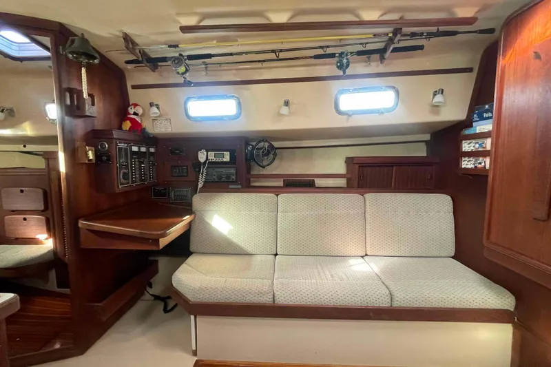 Slide: The Image of 1989 Island Packet 35 yacht interior with cozy seating, fishing rods, and navigation equipment. - 6