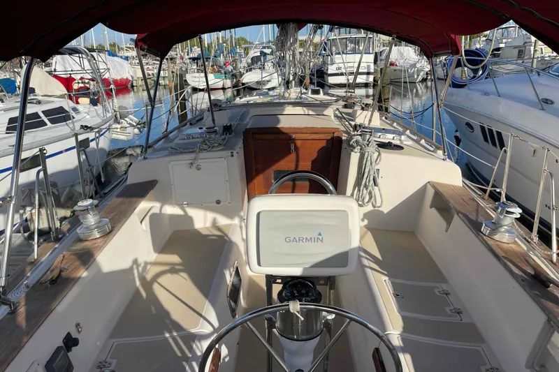 Slide: The Image of 1989 Island Packet 35 sailboat cockpit with Garmin navigation, docked in a marina. - 61