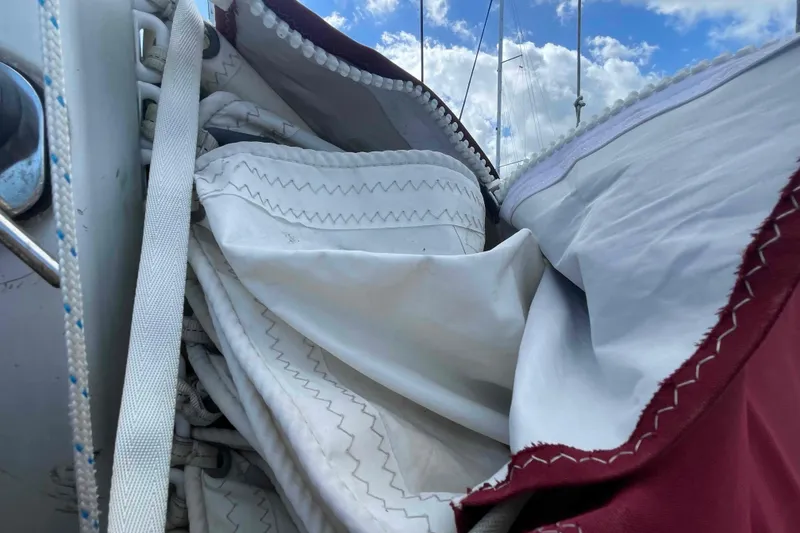 Slide: The Image of 1989 Island Packet 35 sailboat deck with maroon sail cover, docked at marina. - 71