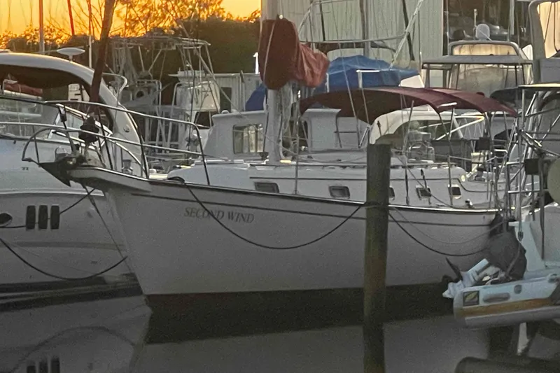 Slide: The Image of 1989 Island Packet 35 sailboat named "Second Wind" docked at sunset. - 79