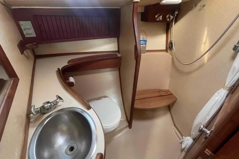 Slide: The Image of 1989 Island Packet 35 yacht bathroom with sink, toilet, and shower area. - 8
