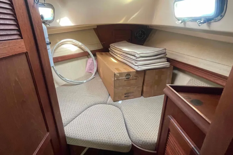 Slide: The Image of Cozy cabin interior of 1989 Island Packet 35 sailboat with cushions and storage boxes. - 9