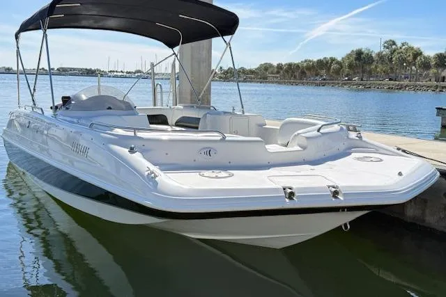 Slide: The Image of 2011 Hurricane SunDeck Sport 201 OB boat docked on calm water with canopy. - 11