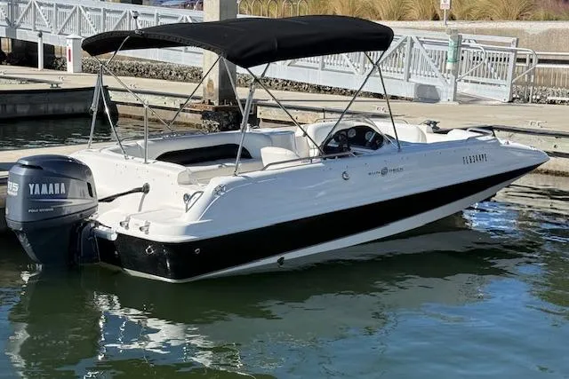 Slide: The Image of 2011 Hurricane SunDeck Sport 201 OB boat docked, featuring a Yamaha outboard motor and black canopy. - 12