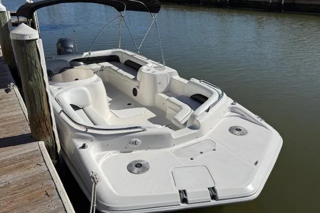 Slide: The Image of 2011 Hurricane SunDeck Sport 201 OB boat docked on calm water. - 13