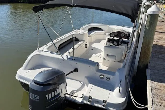 Slide: The Image of 2011 Hurricane SunDeck Sport 201 OB boat docked, featuring Yamaha 115 outboard motor and black canopy. - 14