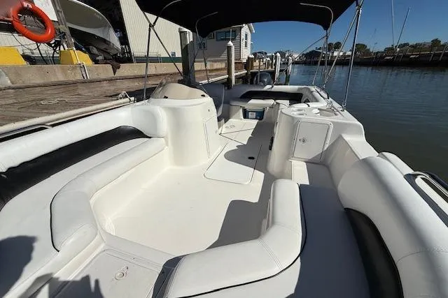 Slide: The Image of 2011 Hurricane SunDeck Sport 201 OB boat with spacious seating and canopy, docked by the water. - 21