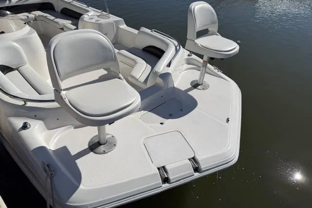 Slide: The Image of 2011 Hurricane SunDeck Sport 201 OB boat with white seating and spacious deck on calm water. - 23