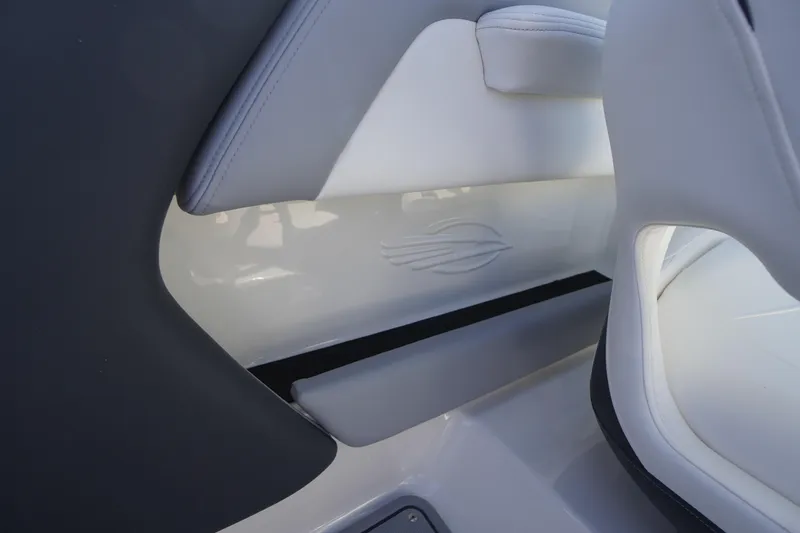 Slide: The Image of Interior detail of 2026 Chaparral 21 SSi OB boat, featuring sleek white and gray seating. - 34