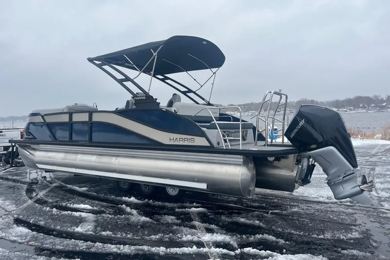Slide: The Image of 2026 Harris Grand Mariner 230 pontoon boat on snowy lakeside, featuring a Mercury outboard motor. - 4