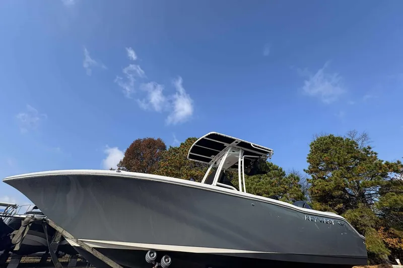 The Image of 2023 Key West 203 FS boat against a clear blue sky and trees. - 0