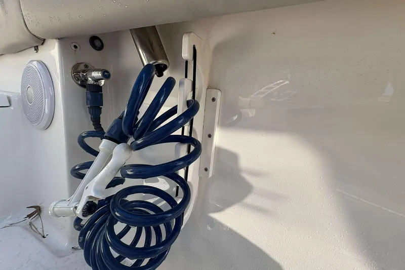 Slide: The Image of Coiled blue hose on 2023 Key West 203 FS boat, with speaker and nozzle. - 13