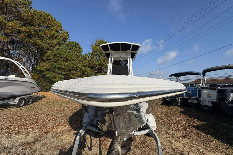 Slide: The Image of 2023 Key West 203 FS boat on trailer, surrounded by trees and other boats. - 7
