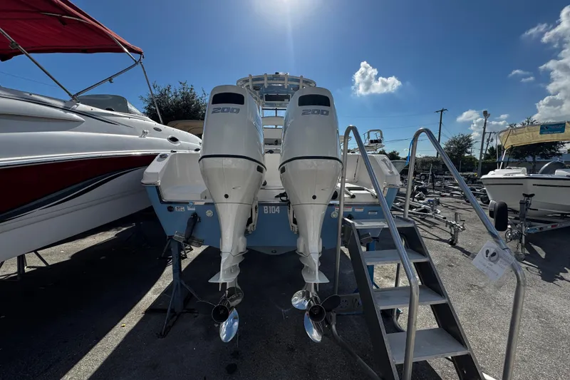 Slide: The Image of 2019 Sea Chaser 27 HFC boat with dual 200 horsepower engines, docked under clear sky. - 36