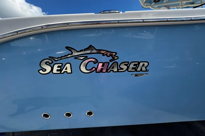 Slide: The Image of 2019 Sea Chaser 27 HFC boat logo on light blue hull under clear sky. - 37
