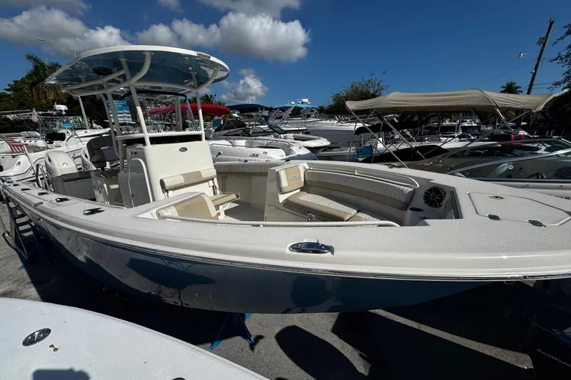 The Image of 2019 Sea Chaser 27 HFC boat with spacious seating, docked under a clear blue sky. - 0