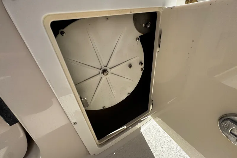 Slide: The Image of 2019 Sea Chaser 27 HFC storage compartment with circular cover, open door. - 23