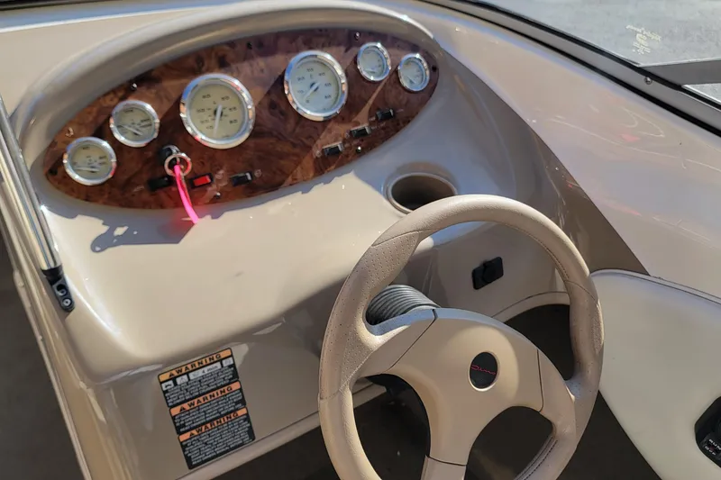 Slide: The Image of 2004 Bayliner 215 Classic boat dashboard with steering wheel and gauges. - 10