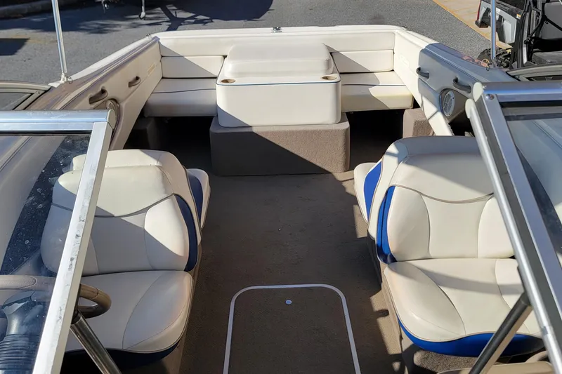 Slide: The Image of 2004 Bayliner 215 Classic boat interior with beige and blue seating. - 6