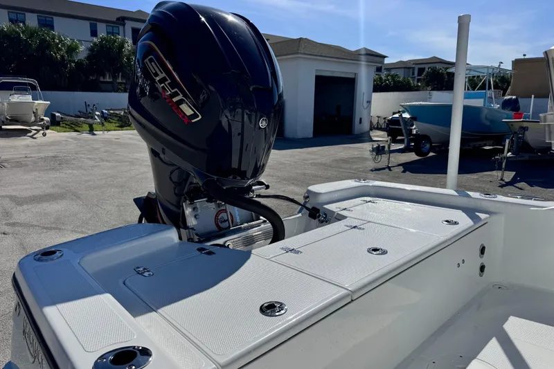 Slide: The Image of 2026 BlackJack 224 boat with powerful outboard motor in a sunny marina setting. - 12