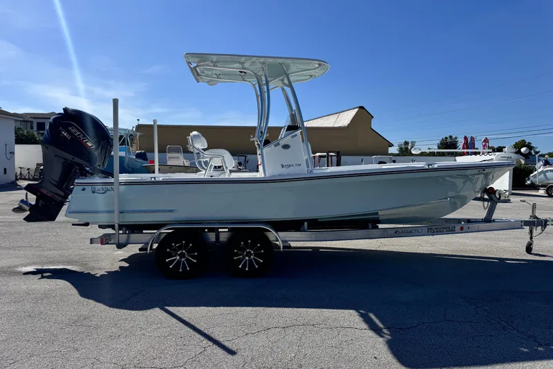 Slide: The Image of 2026 BlackJack 224 boat on trailer, parked outdoors under clear blue sky. - 5