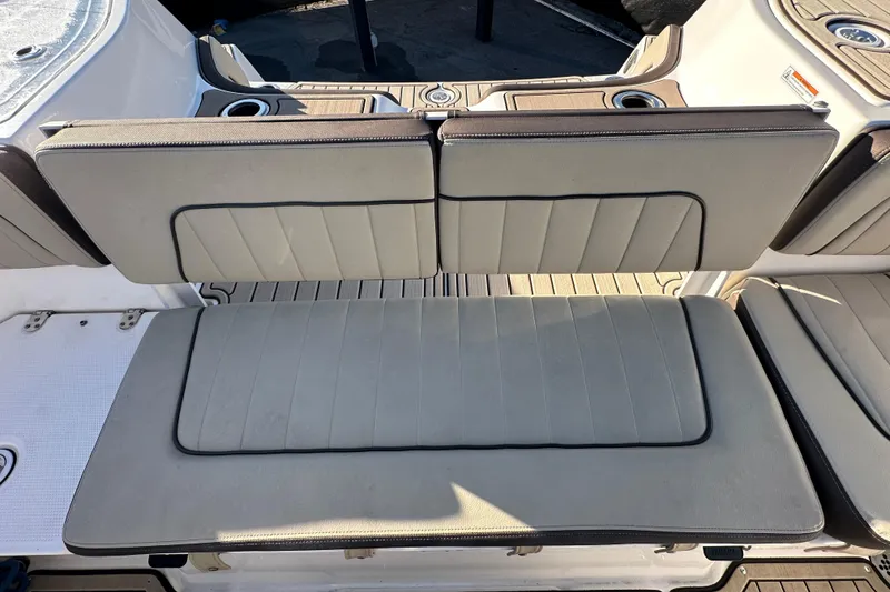 Slide: The Image of 2022 Yamaha Boats 252 FSH Sport seating area with cushioned bench and cup holders. - 105