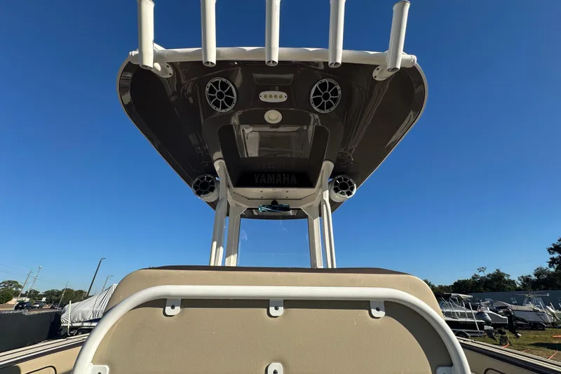 Slide: The Image of 2022 Yamaha Boats 252 FSH Sport center console with speakers, under clear blue sky. - 20