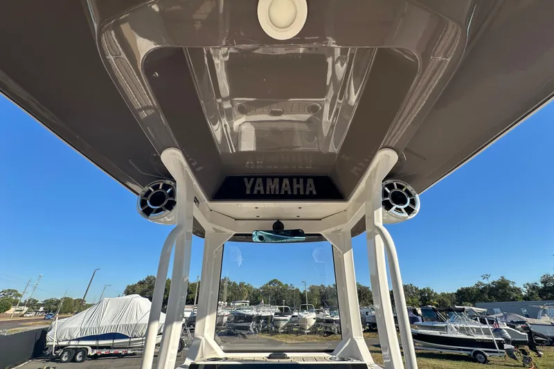 Slide: The Image of 2022 Yamaha Boats 252 FSH Sport, view of T-top and speakers, outdoor setting. - 24