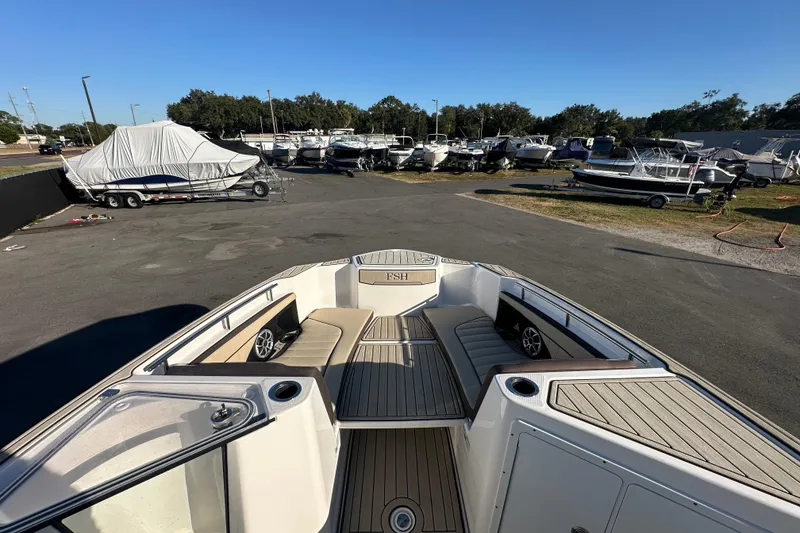 Slide: The Image of 2022 Yamaha Boats 252 FSH Sport in a boatyard, showcasing spacious deck and seating. - 52