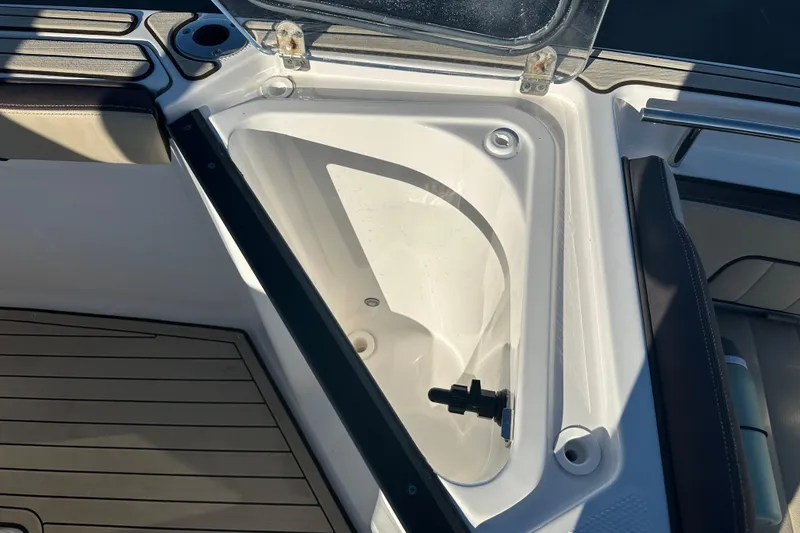 Slide: The Image of Open storage compartment on 2022 Yamaha Boats 252 FSH Sport, featuring sleek design and functionality. - 56