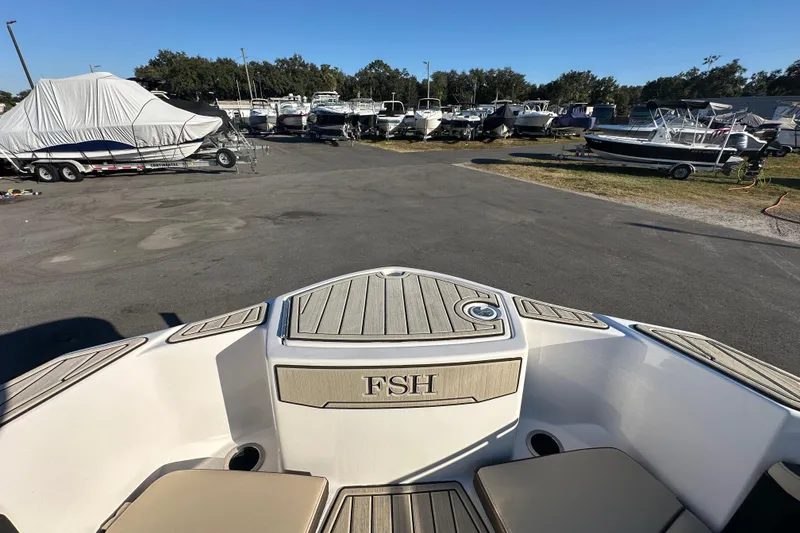 Slide: The Image of 2022 Yamaha Boats 252 FSH Sport at a marina with other boats. - 63