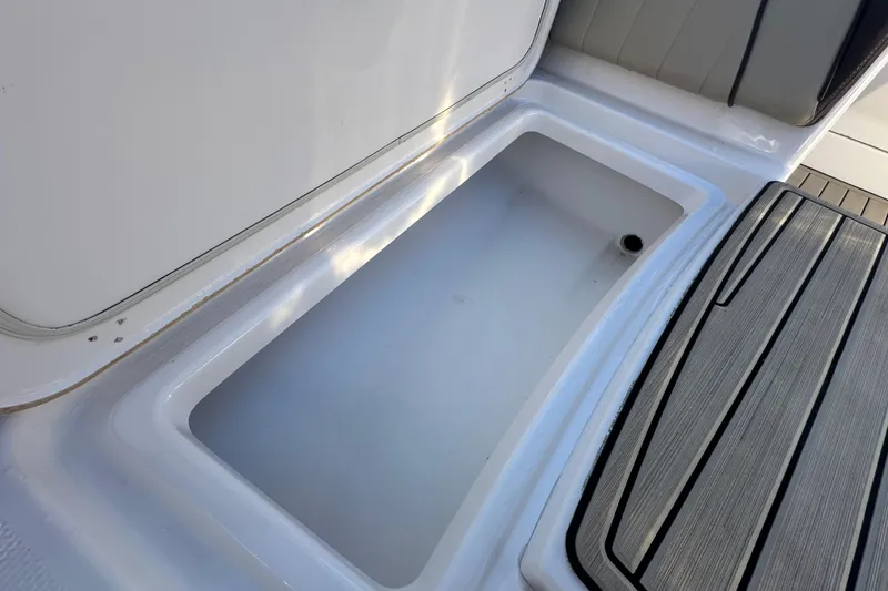 Slide: The Image of Open storage compartment on 2022 Yamaha Boats 252 FSH Sport, featuring sleek design and durable materials. - 73