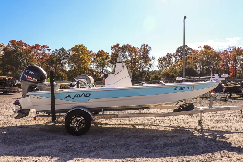 Slide: The Image of 2023 Avid 19 FS boat on trailer with Yamaha engine, parked outdoors. - 3