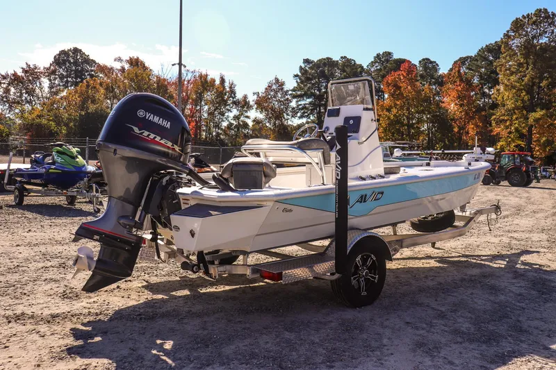 Slide: The Image of 2023 Avid 19 FS boat with Yamaha engine on trailer, surrounded by autumn trees. - 4