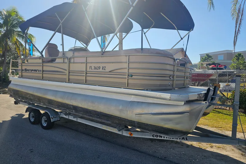 Slide: The Image of 2008 Sanpan 2200 RE-3 Gate pontoon boat on trailer, parked outdoors. - 1