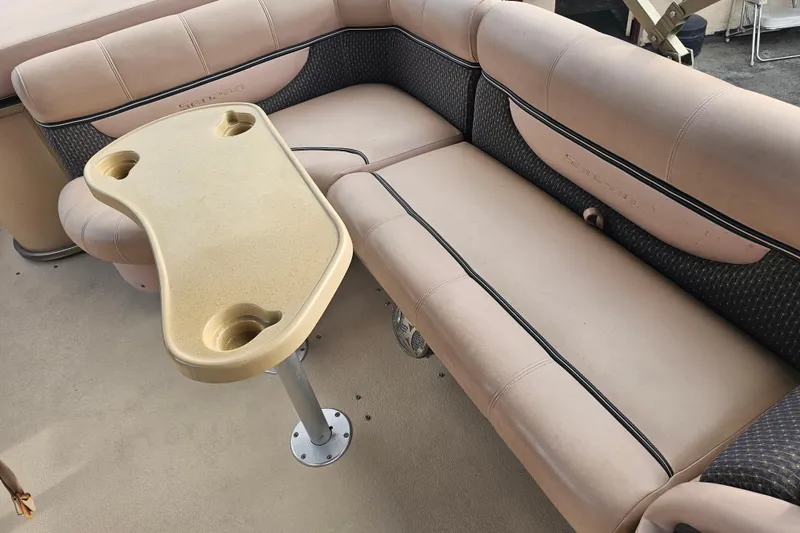 Slide: The Image of 2008 Sanpan 2200 RE-3 Gate boat interior with beige seating and table with cup holders. - 9