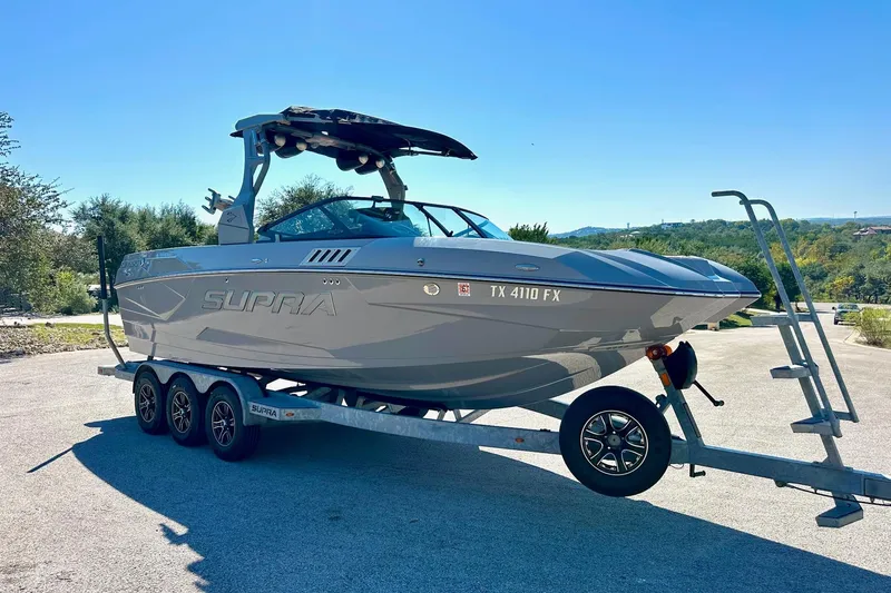 Slide: The Image of 2020 Supra SE550 boat on trailer in sunny outdoor setting. - 14
